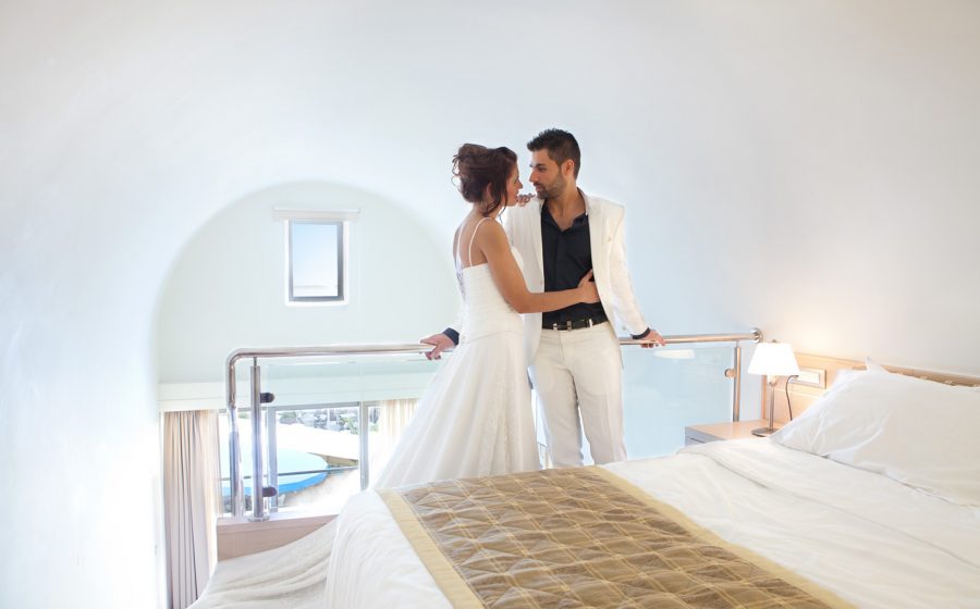 Married couple standing next to bed