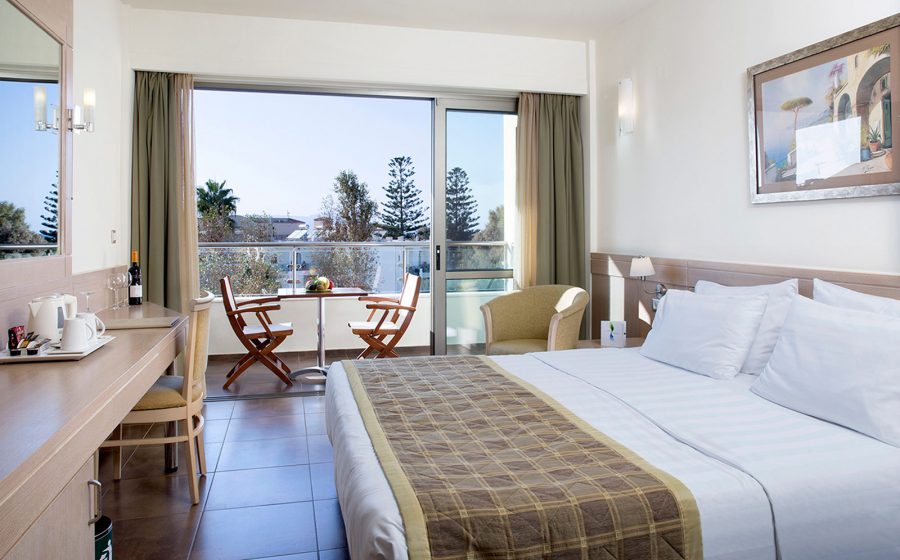 Standard room bed, desk with chair and view of balcony