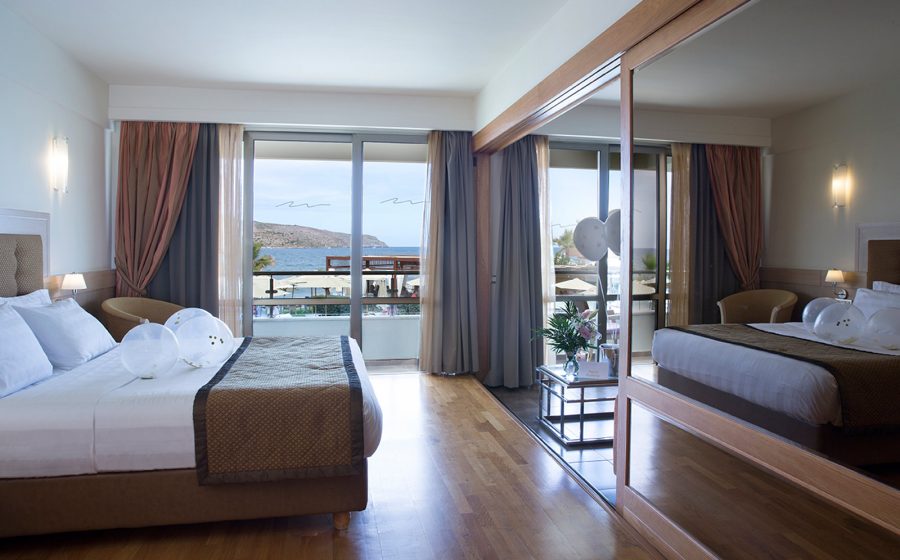 Bed and mirror of a superior suite, view of the sea