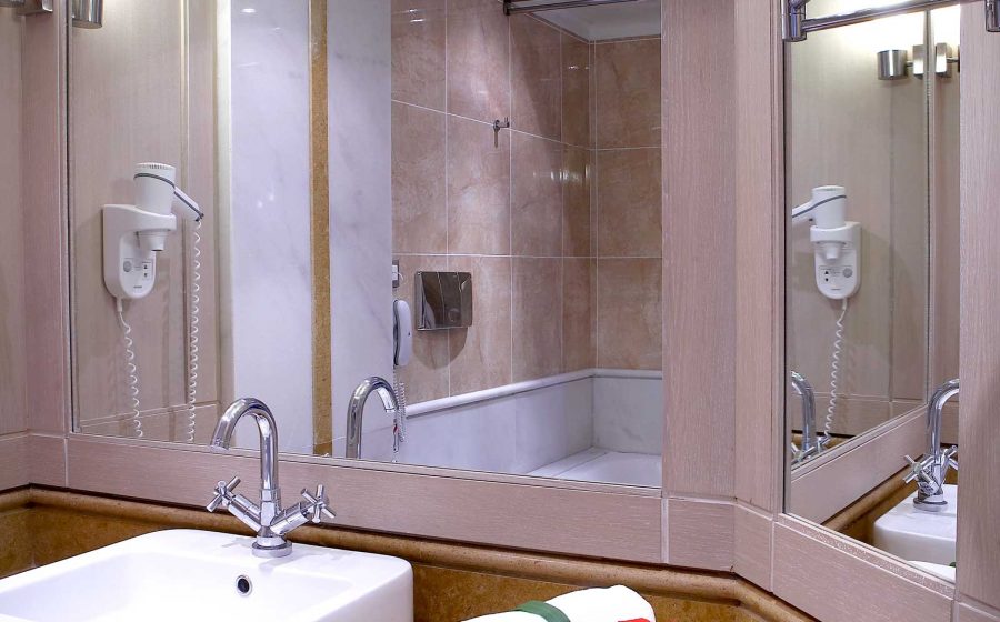 Bathroom with mirrors, a hair dryer and many towels