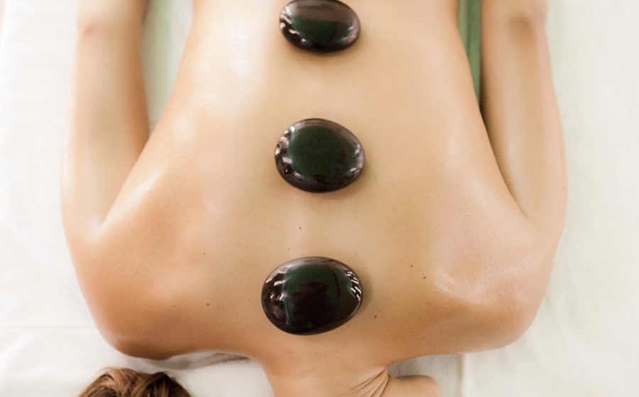 Therapeutic stones on woman laying in bed