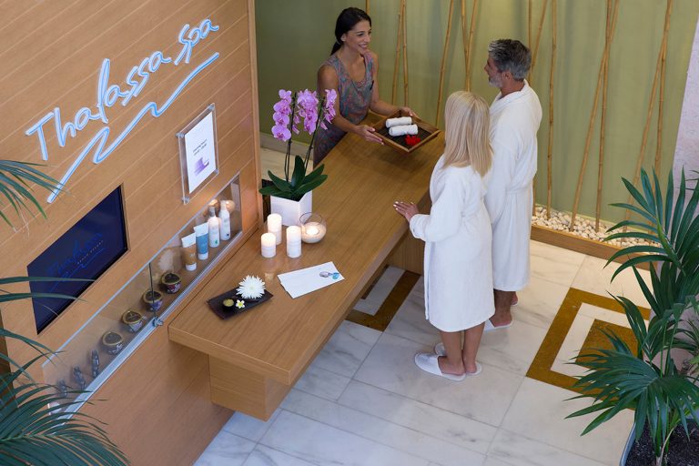 Staff of the spa reception offering towels to couple