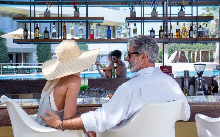 Couples relaxing by the pool bar