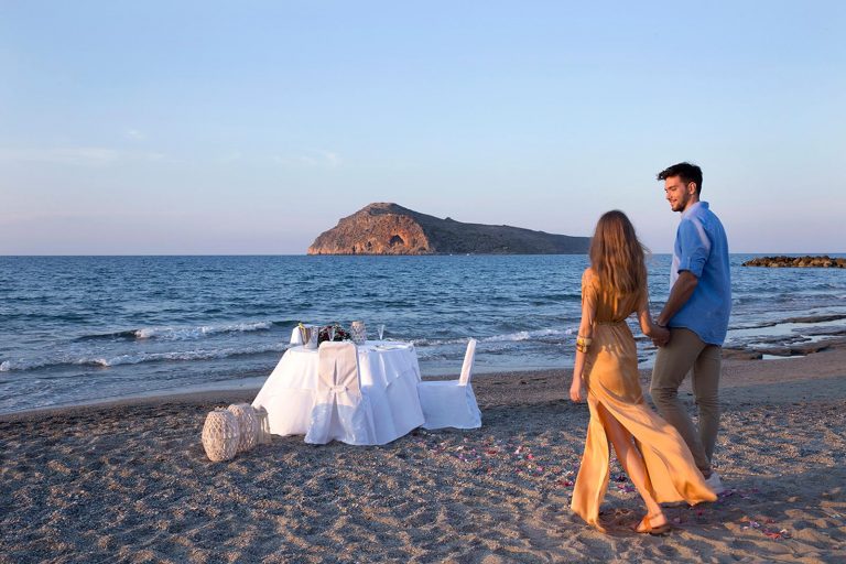 Couple walking to a table by the seaside