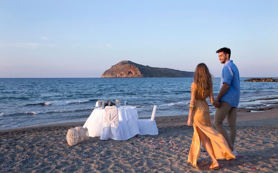 Couple marchant vers une table au bord de la mer